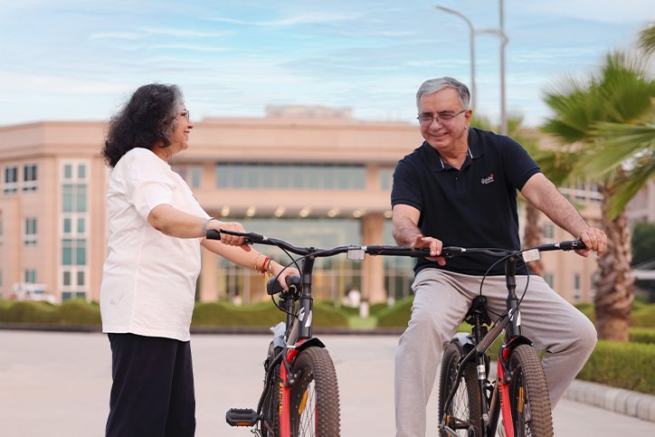 Senior couple enjoying a morning bicycle ride at Saral Satya Legacy