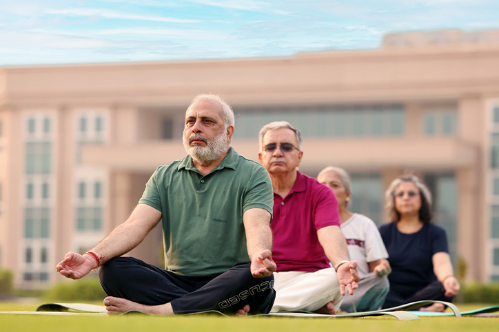 Senior residents practicing morning yoga for healthy living at Saral Satya Legacy