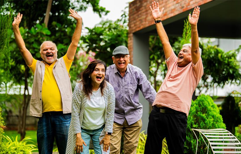 A joyful group of seniors enjoying outdoor activities in a green garden, representing the lively community atmosphere offered by affordable senior living options.