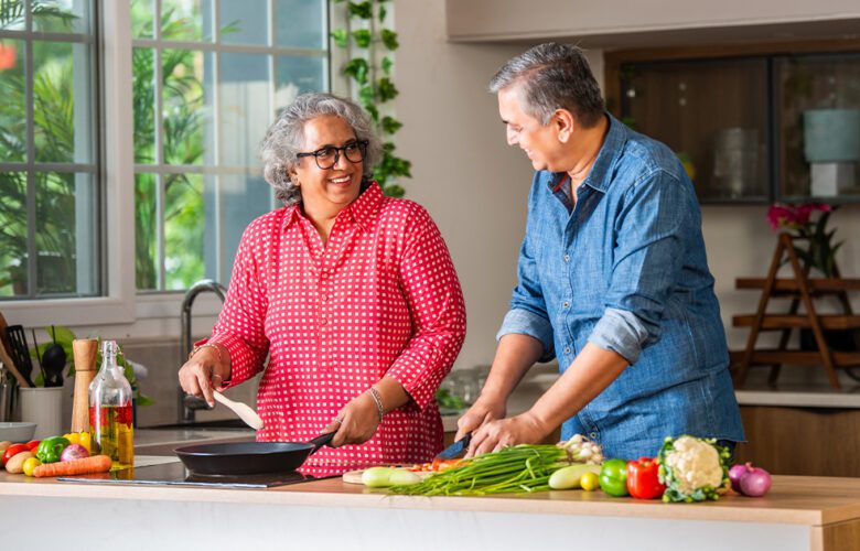 Senior couple preparing healthy winter meals in a modern kitchen, highlighting nutrition and diet tips for seniors living in retirement communities at Saral Satya Legacy.