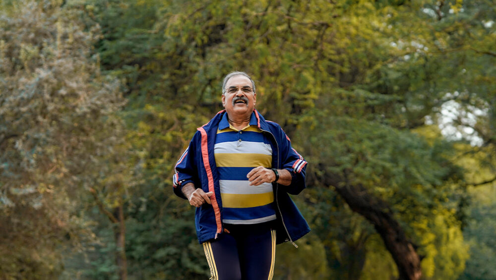 Senior man jogging in a park, demonstrating active lifestyle habits that support healthy ageing.