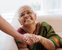 Smiling senior woman interacting with a caregiver at a rental old age home, reflecting daily care, companionship, and support at Saral Satya Legacy.
